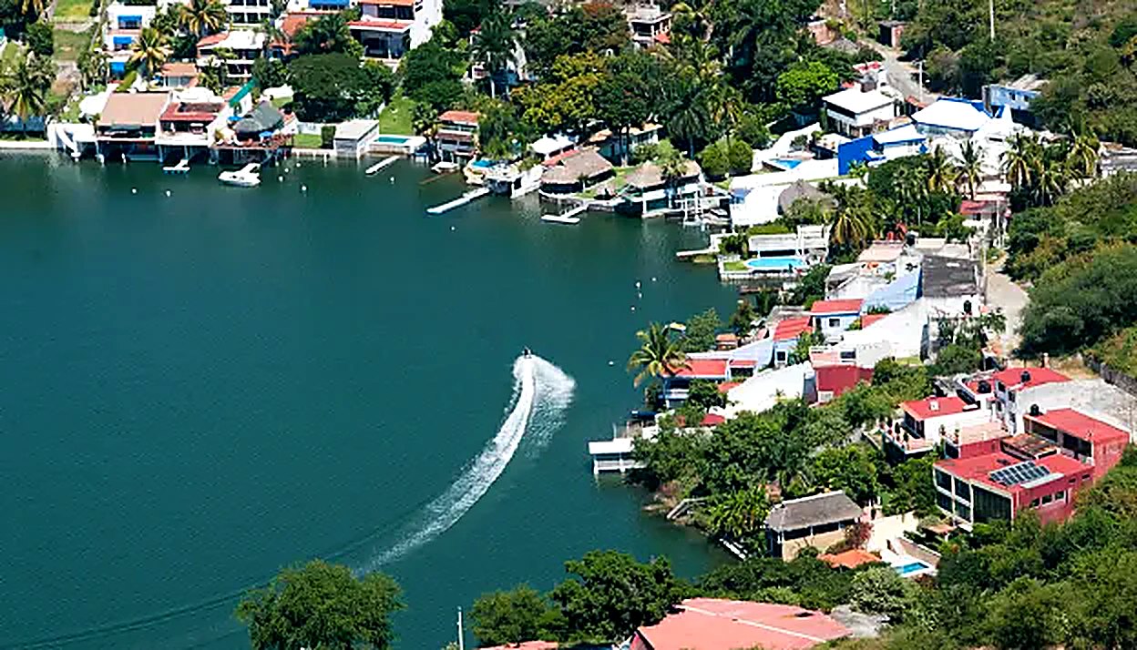Aerial view of Lake Tequesquitengo with lakeside homes and a boat crossing the water, Morelos Mexico
